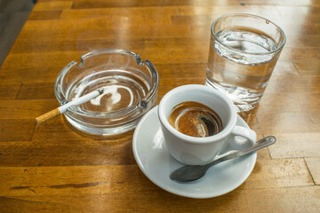 An aromatic cup of espresso coffee, on a saucer, shot from above on the wooden table.