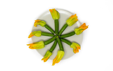 composizione zucchine mignon con fiore su piatto bianco 