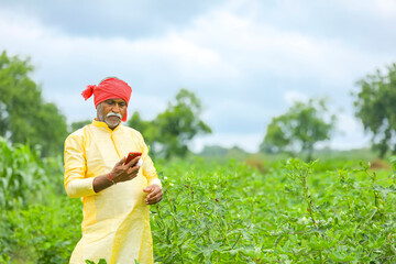 Indian farmer using mobile phone at Agriculture field