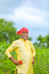 Indian / Asian farmer standing at agriculture field