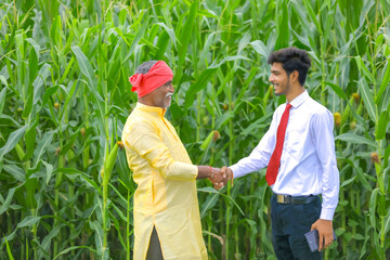 Indian farmer with agronomist at Corn field and hand shaking
