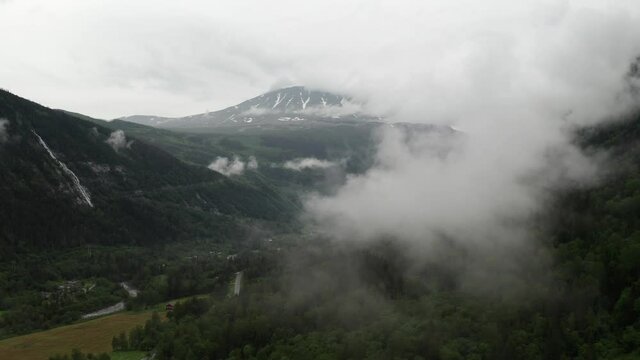 Norwegian mountain Gaustatoppen drone view from Rjukan valley. Aerial view into low hanging clouds on beautiful rainy morning in summer time