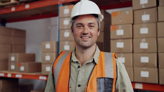 Caucasian engineer smiling wearing hard hat in packaging factory 