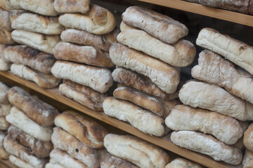 A stack of rustic baguettes at a bakery.