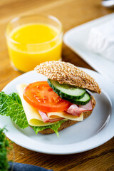 Continental breakfast with orange juice and sandwich. Selective focus on subject.
