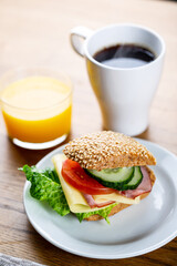 Continental breakfast with coffee, orange juice and sandwich. Selective focus on subject.