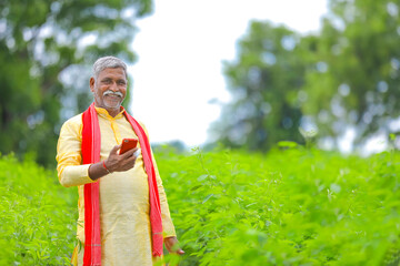 Indian farmer using mobile phone at Agriculture field