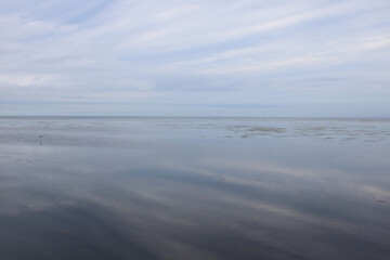 Naklejka na ściany i meble Clouds reflected on the surface of the sea