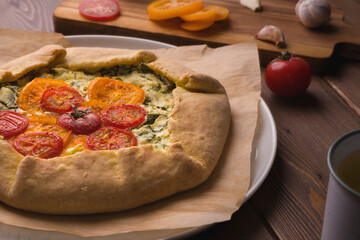 Pizza with cheese and tomatoes on a wooden background in rustic style