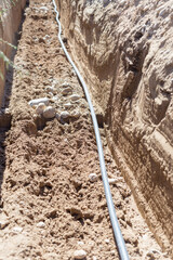 A dug trench in the ground is a pipeline for supplying water over a long distance to residential buildings