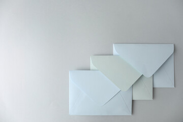 White paper envelopes on light grey background, top view. Space for text