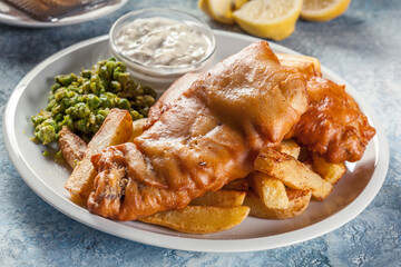 Fish in beer batter and chips with green pea and tartar sauce
