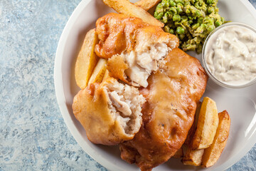 Fish in beer batter and chips with green pea and tartar sauce
