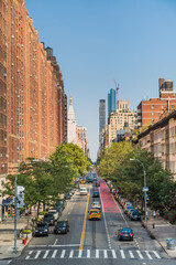 Manhattan street where you can see pedestrians and cars in an evening light