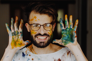 Portrait of an artist with paints on his face and clothes