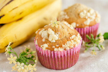 Piece of banana crumble and sesame cupcake or muffin in mini pink cup on table in close up view. Banana cupcake topping with crumbles so sweet and tasty. Homemade bakery with simply delicious concept.
