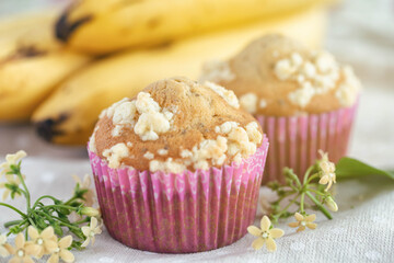 Piece of banana crumble and sesame cupcake or muffin in mini pink cup on table in close up view. Banana cupcake topping with crumbles so sweet and tasty. Homemade bakery with simply delicious concept.