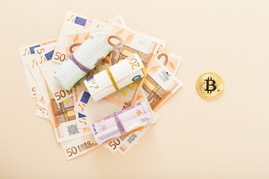 Golden bitcoins with euro banknotes as a background. Virtual crypto currency, digital concept.