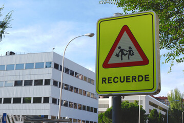 Roadsign protecting kids from cars hazard on the street of Madrid, Spain. Word on traffic sign in Spanish means "remember". Regulation caution on the road
