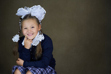 Young girl in school uniform with hair bow.