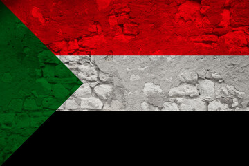 national flag of the state of Sudan on an old stone wall with cracks, the concept of tourism, emigration, economy, politics, civil rights and freedoms