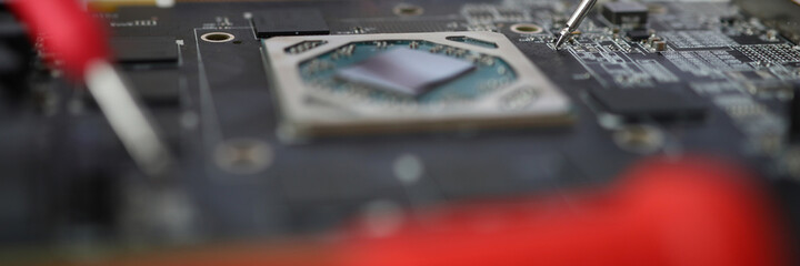 Master makes diagnostics of motherboard with tester. Electronic circuit board service concept