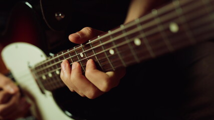 Fototapeta na wymiar Musician playing electric guitar in studio. Guitarist hand pinching chords