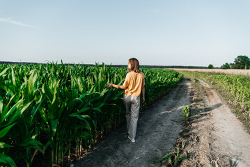 young woman in a corn field in a yellow t-shirt with a place under the text with short hair