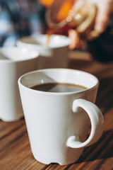 Fototapeta premium The coffee is alternatively made using a paper filter and a kemex is poured from the flask into a mug. Third wave cafe