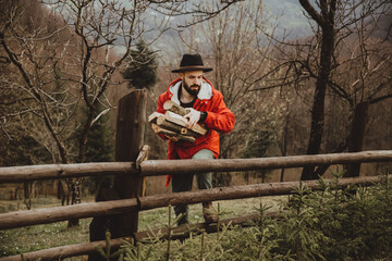 Hipster with beard,  Man in hat and warm jacket chopping and preparing firewood for picnic