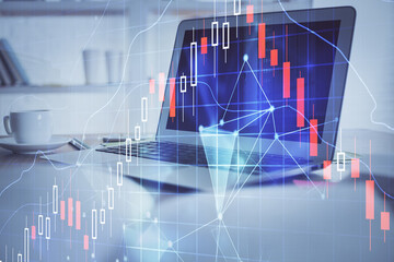 Stock market graph on background with desk and personal computer. Multi exposure. Concept of financial analysis.