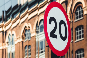 Close up shot of speed limit sign in an urban environment. Blurred background with mirrored facade...