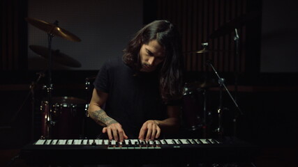 Fototapeta na wymiar Man playing keyboard in music studio. Guy smiling in recording studio.