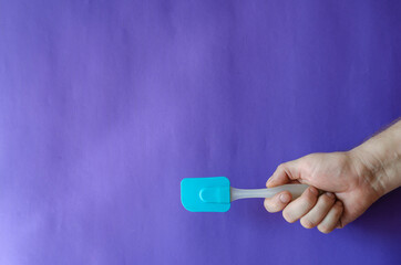 Kitchen silicone spatula in hand.