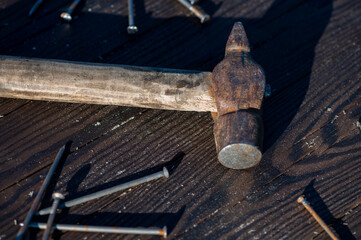 Old vintage hammer and nails on a wooden background, close-up, selective focus.