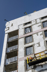 Thermal insulation of the walls of a new unfinished apartment building.