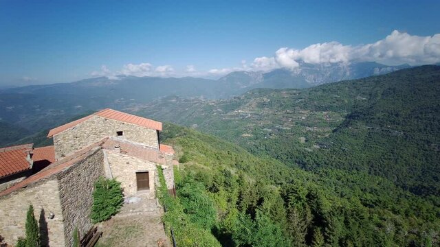 Stone houses of Bajardo overlooking green valleys, Ligurian Alps, Italy