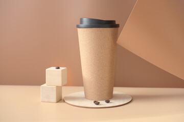 trendy coffee mug and coffee beans on a beige background. coffee to go or take away drink in reusable mug. sustainable and eco product. minimal style. 