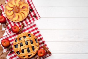Autumn thankgiving pies on white wooden board decorated with dry leaves and cinnamon sticks © fotofabrika
