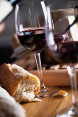 Wine glasses on table with bread and jam, dark background. Shallow depth of field, selective focus