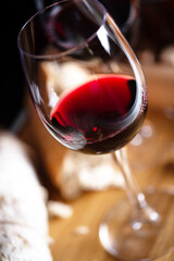 Wine glass on table with food in background. Shallow depth of field, selective focus