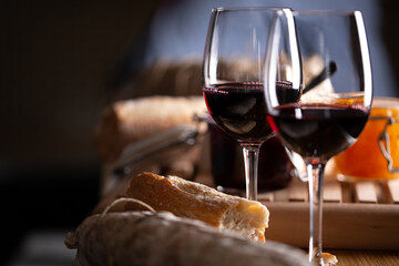 Wine glasses on table with bread and jam, dark background. Shallow depth of field, selective focus - Powered by Adobe