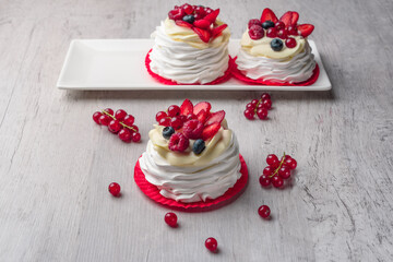 Pavlova meringue cake with cream and raspberries, blueberries, strawberries, currants