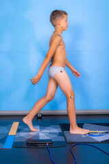 Baropodometry, child making initial heel contact with a foot plate during anthropometric test