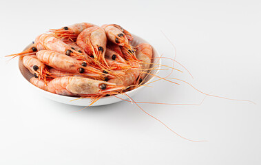 Many shrimps in a white bowl in a bright studio setting, selective focus