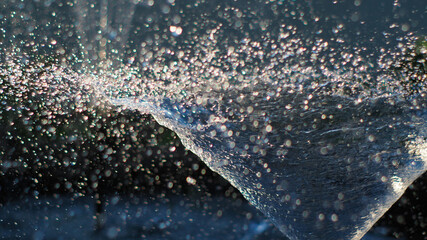 Texture de gouttes d'eau jaillissant d'un petit jet d'eau, dans un bassin