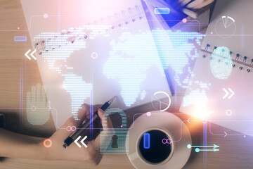 Multi exposure of hands making notes with world map hologram and data theme icons. Concept of global data.
