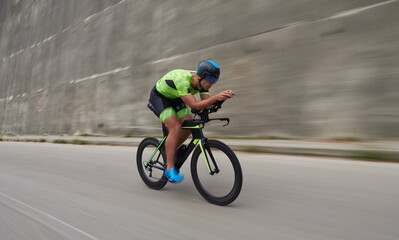 Naklejka premium triathlon athlete riding a bike on morning training