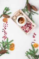 Zero waste Christmas concept. Natural Christmas decoration, cup of coffee, fresh cranberries, pine cones and branches on white wooden background.