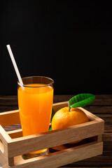 Fototapeta premium Fresh orange juice on wooden basket wood background.